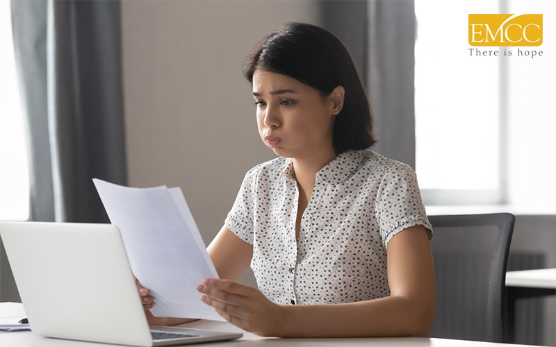 stressed woman holding and looking at papers