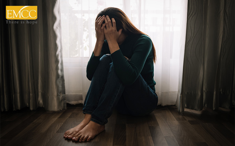 Distressed woman sitting on floor, illustrating link between stress and health.