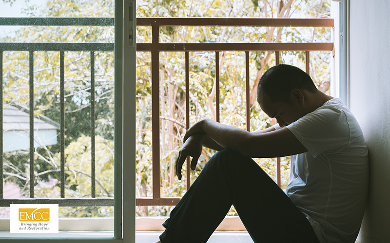 Man sitting alone, struggling with a mental health issue.