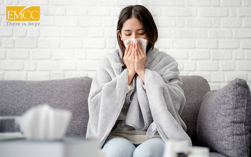 Woman with blanket sneezing, showing stress weakening immune system.